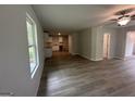 View of open concept living space featuring hardwood floors, white walls, ceiling fan, and adjoining kitchen at 30 Yellow Brick Way # 3, Covington, GA 30014