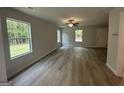 Bright living room featuring hardwood floors, a ceiling fan, and multiple windows for natural light at 30 Yellow Brick Way # 3, Covington, GA 30014
