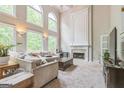 Bright living room features soaring ceilings, large windows, a cozy fireplace, and neutral decor at 2693 Blairsden Nw Pl, Kennesaw, GA 30144