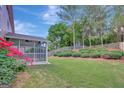Landscaped backyard featuring a screened porch and vibrant roses, creating a serene outdoor setting at 340 Aster Ridge Trl, Peachtree City, GA 30269