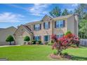 Beautiful two-story home with mature trees, green lawn and a vibrant Japanese maple accenting the front yard at 340 Aster Ridge Trl, Peachtree City, GA 30269