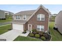 Two-story brick and siding home featuring a well-manicured lawn and a two-car garage at 1560 Avalon Creek Rd, Sugar Hill, GA 30518