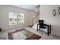 Bright living room featuring a large window, neutral walls, a work desk, and carpet flooring at 1560 Avalon Creek Rd, Sugar Hill, GA 30518
