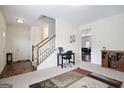 Bright open-concept living area with staircase, neutral walls, a work desk, and hardwood floors at 1560 Avalon Creek Rd, Sugar Hill, GA 30518