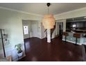 Bright foyer with hardwood floors, stylish pendant lighting, leading to living spaces and a view of the staircase at 1369 Star Water Dr, Lawrenceville, GA 30045