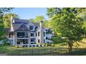 Back exterior showing the pool, black metal fence, stone fireplace, and large windows at 155 Green Meadow Ln, Fayetteville, GA 30215