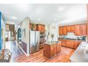 Spacious kitchen featuring wood cabinets, stainless steel appliances, an island, and hardwood floors at 3006 Gold Creek Dr, Villa Rica, GA 30180