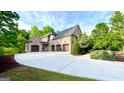 Stunning brick home with a three-car garage, long driveway, and mature landscaping at 1345 Cashiers Way, Roswell, GA 30075