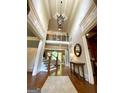 Grand foyer with hardwood floors, soaring ceilings, elegant chandelier, and staircase at 1345 Cashiers Way, Roswell, GA 30075