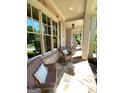 Inviting front porch with brick accents, stone floors, and comfortable wicker seating at 1345 Cashiers Way, Roswell, GA 30075