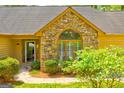 Close-up of the front entrance with stone accents, lush greenery and path leading to the door at 8575 Haven Wood Trl, Roswell, GA 30076