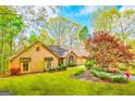 Inviting home featuring a well-manicured lawn and beautifully landscaped flower beds and mature trees at 8575 Haven Wood Trl, Roswell, GA 30076