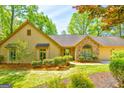Well-maintained home with a stone entrance and mature trees, offering a serene setting at 8575 Haven Wood Trl, Roswell, GA 30076