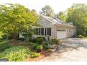 Side view of a brick home with a two-car garage, well-maintained landscaping, and a circular driveway at 17 Hampton Way, Carrollton, GA 30116