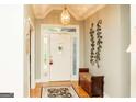 Inviting foyer featuring a decorative front door with sidelights, hardwood floors, and a bench at 17 Hampton Way, Carrollton, GA 30116