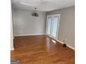 Bright living room featuring vinyl floors, a decorative light fixture, and access to outdoor space at 3818 Mulkey Sw Cir, Marietta, GA 30008