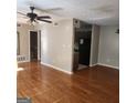 Open living room with vinyl floors transitions to the kitchen with dark appliances and cabinetry at 3818 Mulkey Sw Cir, Marietta, GA 30008