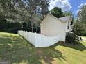 View of expansive, fenced backyard and side of home with traditional architectural details at 85 Creekside Trl, Covington, GA 30016