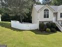 View of expansive, fenced backyard and side of home with traditional architectural details at 85 Creekside Trl, Covington, GA 30016