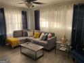 Cozy living room with a comfortable gray sectional sofa, stylish decor, and ample natural light from large windows at 3385 M L King Jr Sw Dr, Atlanta, GA 30331