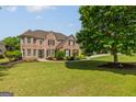 Traditional brick home with manicured lawn and landscape, complemented by dark shutters and detailed entrance at 1120 Twin Bridge Ln, Peachtree City, GA 30269