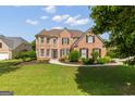 Traditional brick home with manicured lawn and landscape, complemented by dark shutters and detailed entrance at 1120 Twin Bridge Ln, Peachtree City, GA 30269