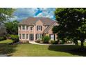 Traditional brick home with manicured lawn and landscape, complemented by dark shutters and detailed entrance at 1120 Twin Bridge Ln, Peachtree City, GA 30269