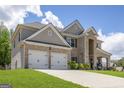 Charming brick and siding home with a two-car garage and a concrete driveway, perfect for Gathering living at 150 Gadson Dr, Fayetteville, GA 30214