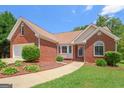 Well-maintained brick home with lush landscaping, a sidewalk, and a welcoming front entrance at 3533 Saddlebrook Dr, Loganville, GA 30052