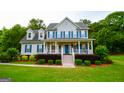 Inviting two-story home with blue shutters, manicured landscaping, and a welcoming front porch at 855 Hood Rd, Fayetteville, GA 30214