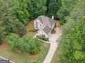 Aerial view of a home with lush, mature trees, a long driveway, and well-maintained landscaping at 215 Barrington Grange Dr, Sharpsburg, GA 30277