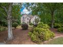 Two-story home showcasing manicured landscaping, mature trees, and architectural details at 215 Barrington Grange Dr, Sharpsburg, GA 30277