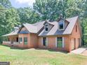 Beautiful brick home showcasing dormer windows, manicured lawn, and mature trees creating a serene setting at 95 Fern Ct, Stockbridge, GA 30281
