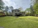 A spacious backyard with a deck, surrounded by mature trees and a wood fence at 780 Sweet Briar Se Trl, Conyers, GA 30094