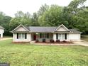 Inviting single-story home with neutral siding, black shutters, and a vibrant red front door at 221 Courthouse Park Dr, Temple, GA 30179