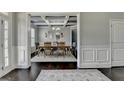 Elegant dining room featuring stylish mirrors and a coffered ceiling, adjacent to foyer at 7575 Old Camp Lndg, Cumming, GA 30040