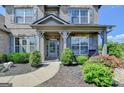 Charming home entrance featuring a covered porch and beautifully landscaped garden at 7575 Old Camp Lndg, Cumming, GA 30040