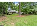Lovely home nestled among mature trees, showcasing its charming curb appeal and inviting ambiance at 1680 Huntington Dr, Marietta, GA 30066