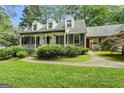 Inviting home featuring a covered front porch, lush landscaping, and charming curb appeal at 1680 Huntington Dr, Marietta, GA 30066