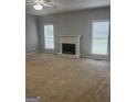 Living room features a decorative fireplace, neutral carpet and natural lighting at 871 Clearwater Rd, Sharpsburg, GA 30277