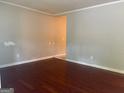 Living room with wood-look floors, neutral walls, and base molding at 8145 Attleboro Dr, Jonesboro, GA 30238