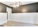 Dining room features sleek modern lighting, gray accent wall, and white wainscoting at 980 Temple Draketown Rd, Temple, GA 30179