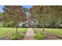 Beautiful two-story home with a red door, lush landscaping, and mature trees at 908 Huntington Pl, Peachtree City, GA 30269