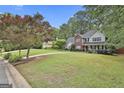 Spacious front yard featuring a well-manicured lawn and mature trees surrounding the property at 908 Huntington Pl, Peachtree City, GA 30269