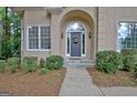 Close-up of the front entrance, featuring a gray door with sidelights and manicured shrubbery at 302 Welton Way, Peachtree City, GA 30269