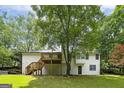 A spacious backyard with a wooden deck, lush lawn, and mature trees at 40 Salem Ct, Mcdonough, GA 30252