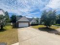 Home featuring a spacious driveway, attached garage, and a neatly landscaped front yard at 6190 Winston Trce, Mcdonough, GA 30252