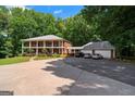 Expansive exterior view of a two-story brick home with a three-car garage and ample parking space at 871 Rocky Creek Rd, Hampton, GA 30228