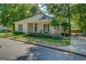 Well-maintained single-story home with green lawn, mature trees, covered porch, and side driveway, perfect for suburban living at 3170 Butler Se Ave, Covington, GA 30014