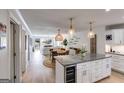 Open-concept kitchen features an island with a wine fridge, granite countertops, pendant lighting, and seamless flow to the living area at 705 Berry Ct, Villa Rica, GA 30180